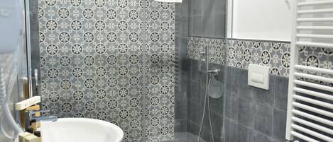A modern bathroom with a shower, toilet, bidet, and sink.