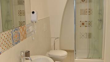 A modern bathroom with a large sink, toilet, and glass-enclosed shower.