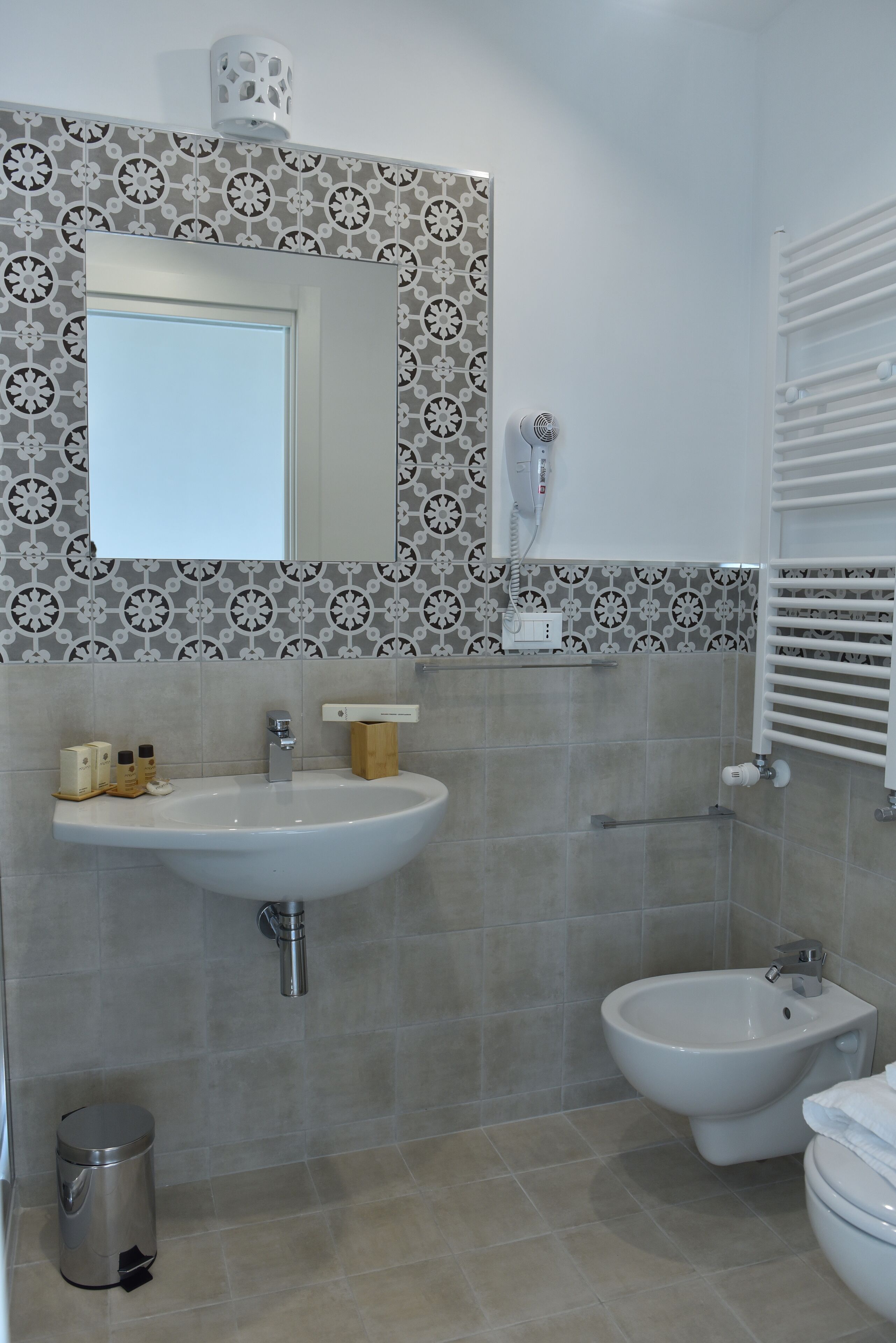 A bathroom with a sink, bidet, and toilet.