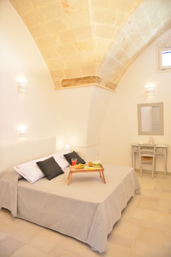 A bedroom with a bed, bedside table, and a tray with fruits and a drink. - Tobacco Suite (Mesagne)