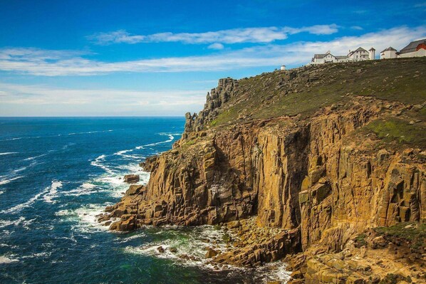 A coastal cliff with a building on top. - The Land's End Hotel (Penzance)