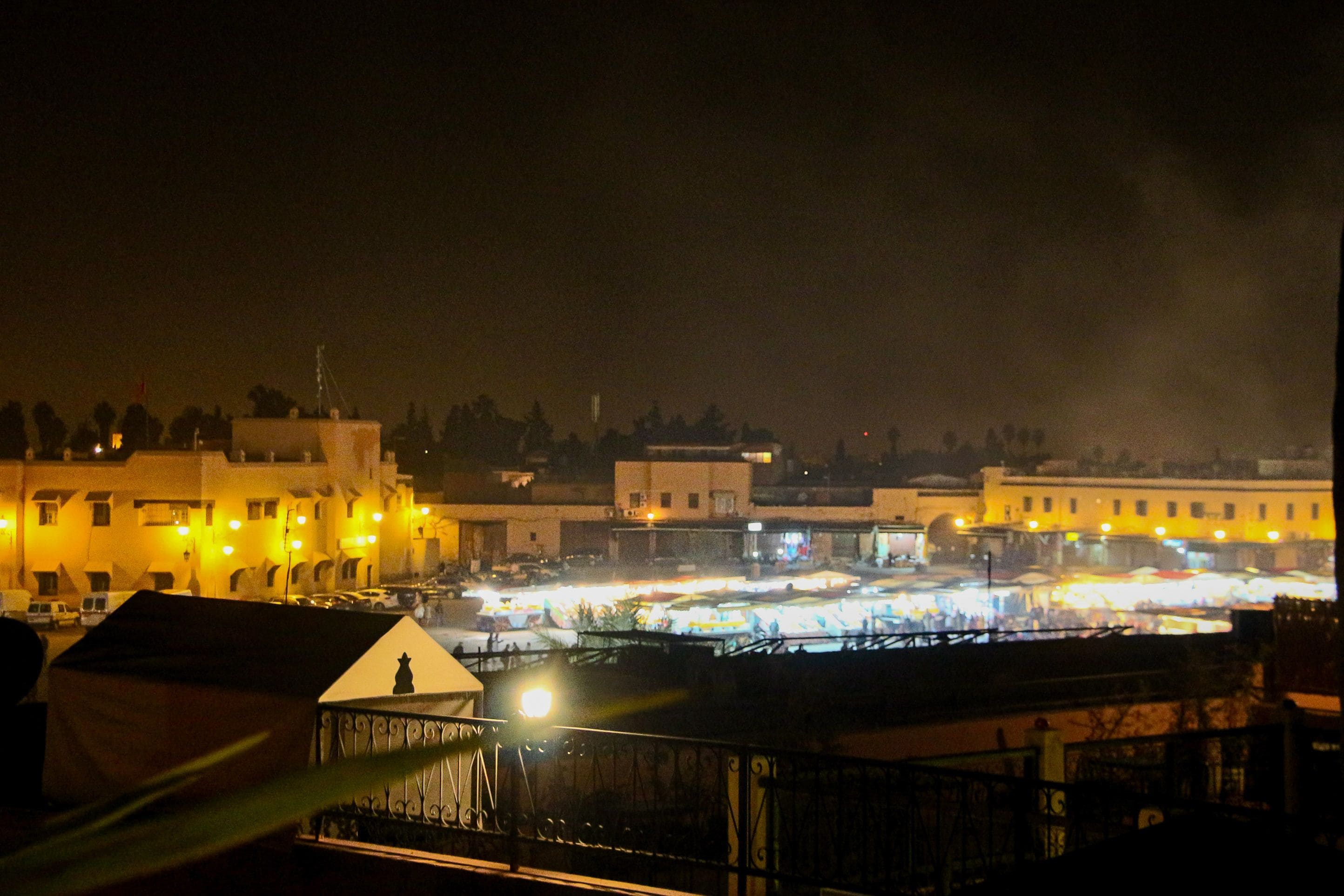 Een nachtzicht op een stadsgezicht met verlichte gebouwen en een drukke straat.