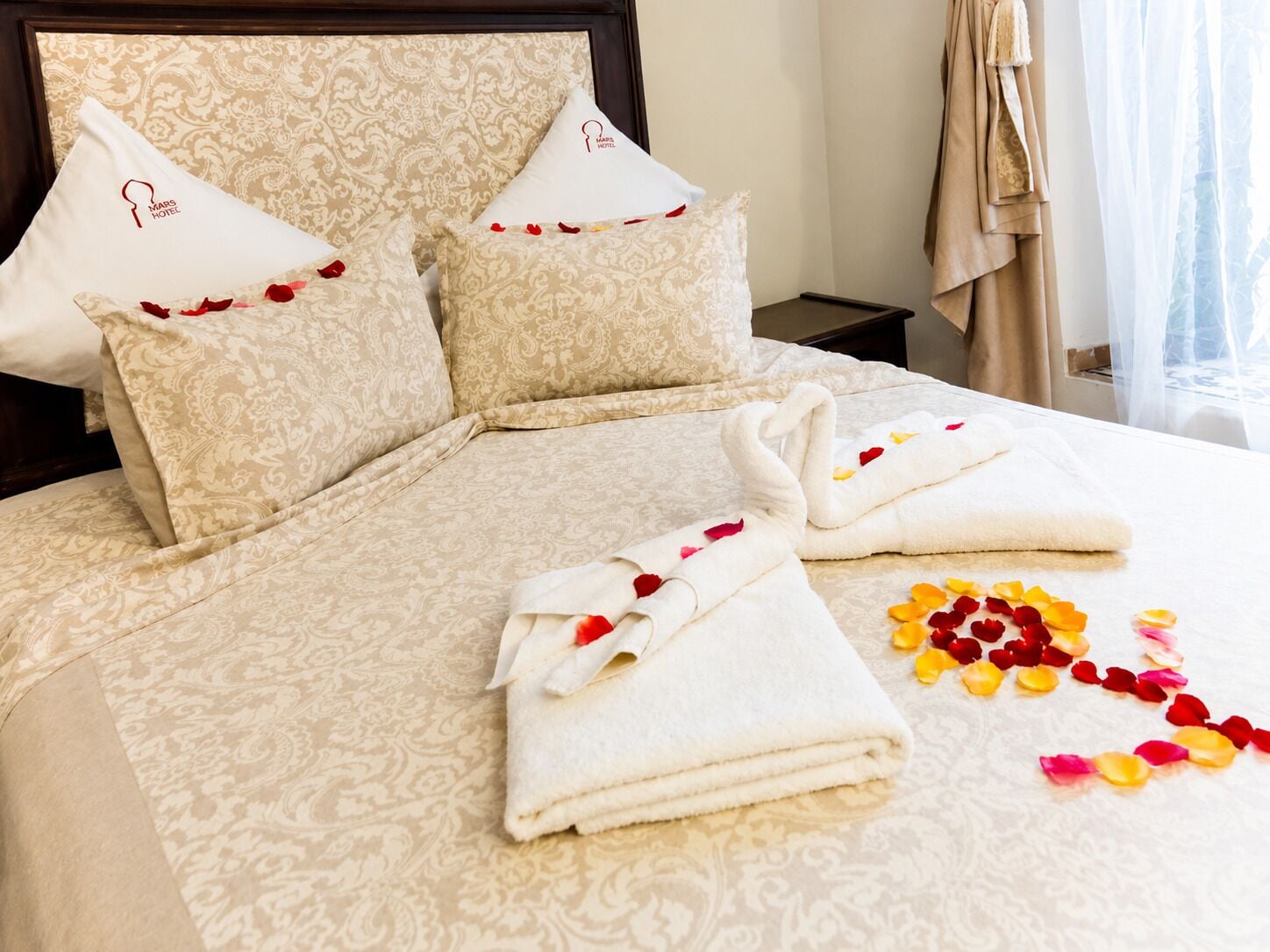 Habitación de hotel con cama, almohadas y toallas preparadas para los huéspedes.