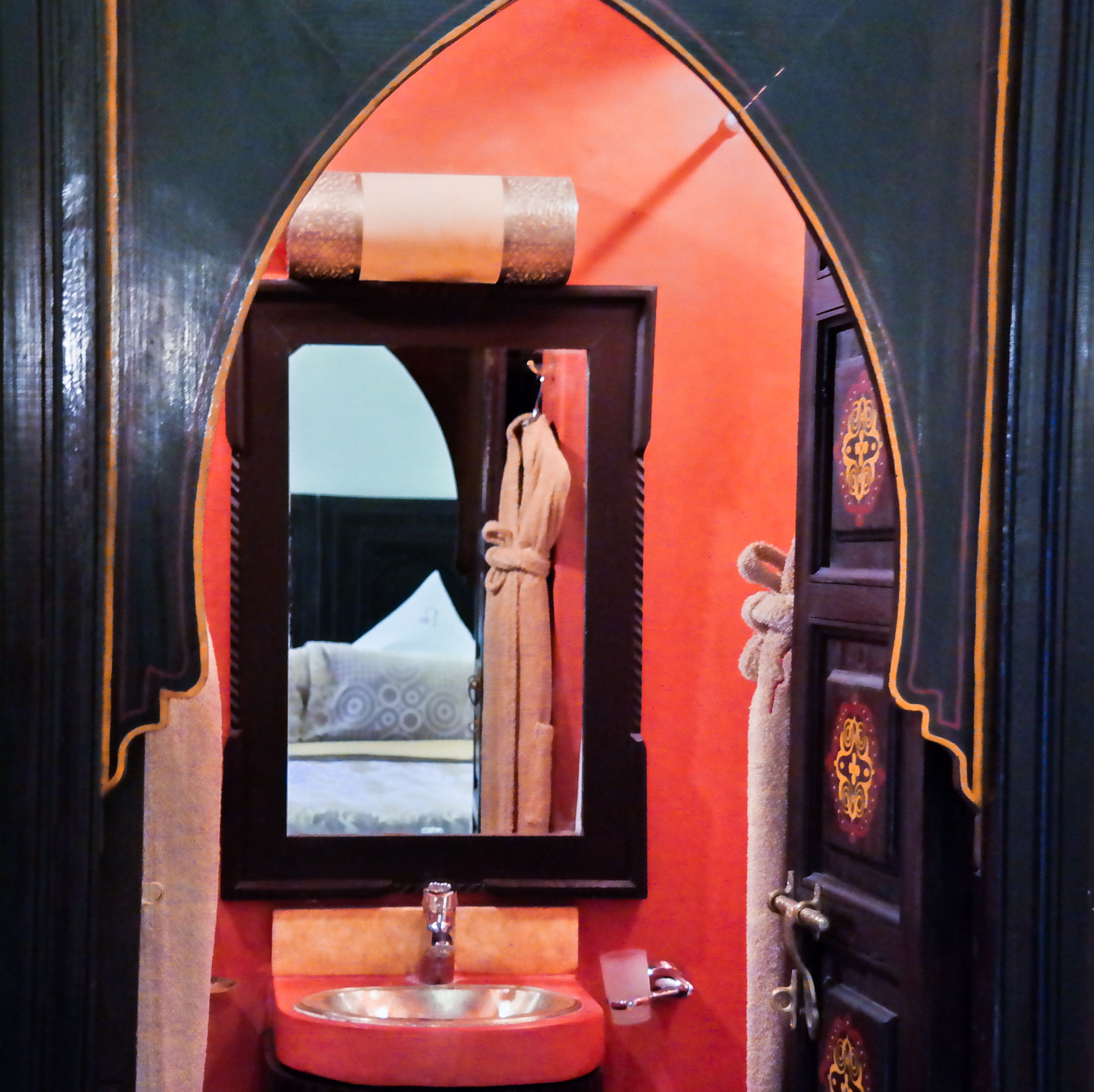 A bathroom with a mirror, sink, and door.