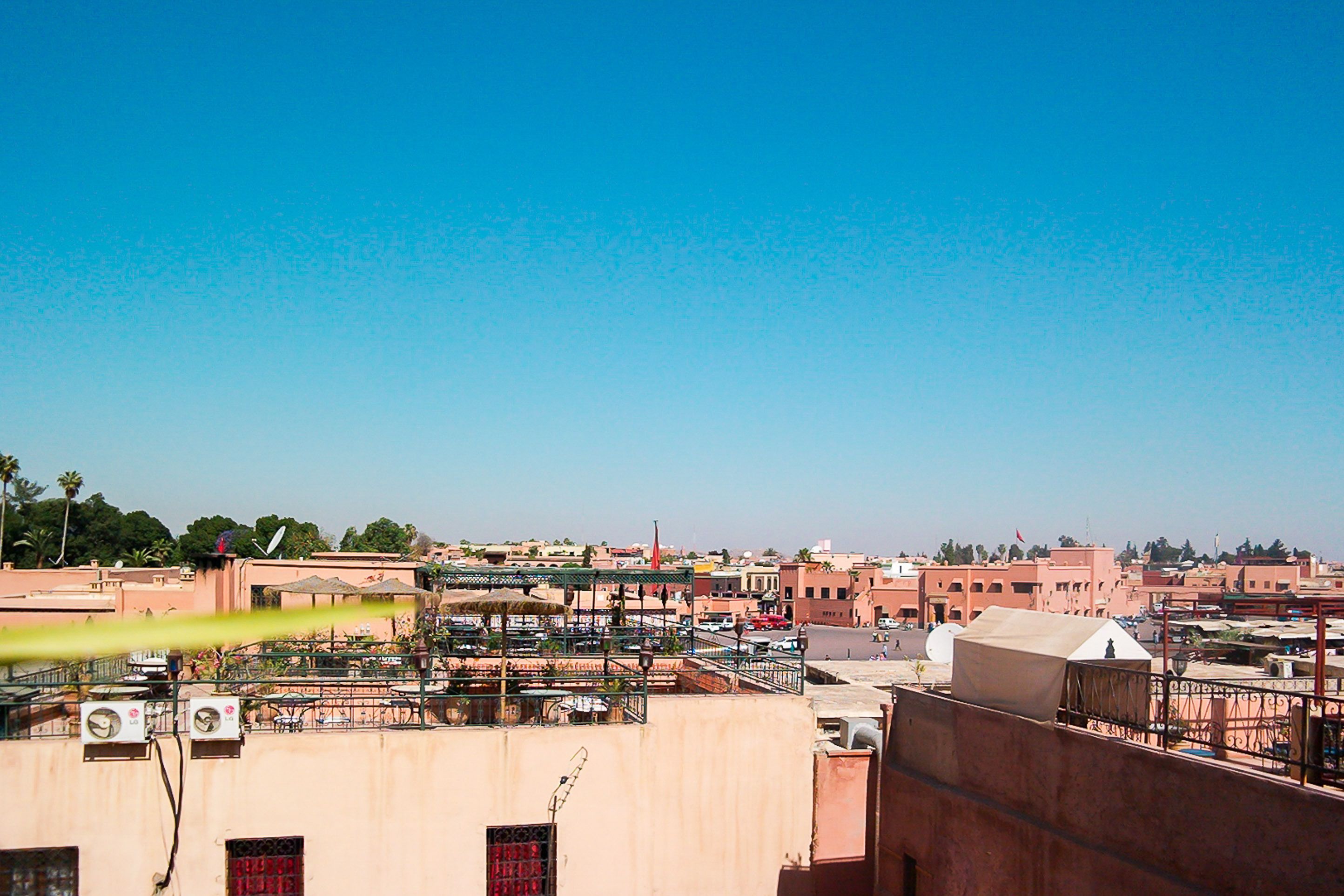 A rooftop with a view of a cityscape, including buildings and a clear sky.