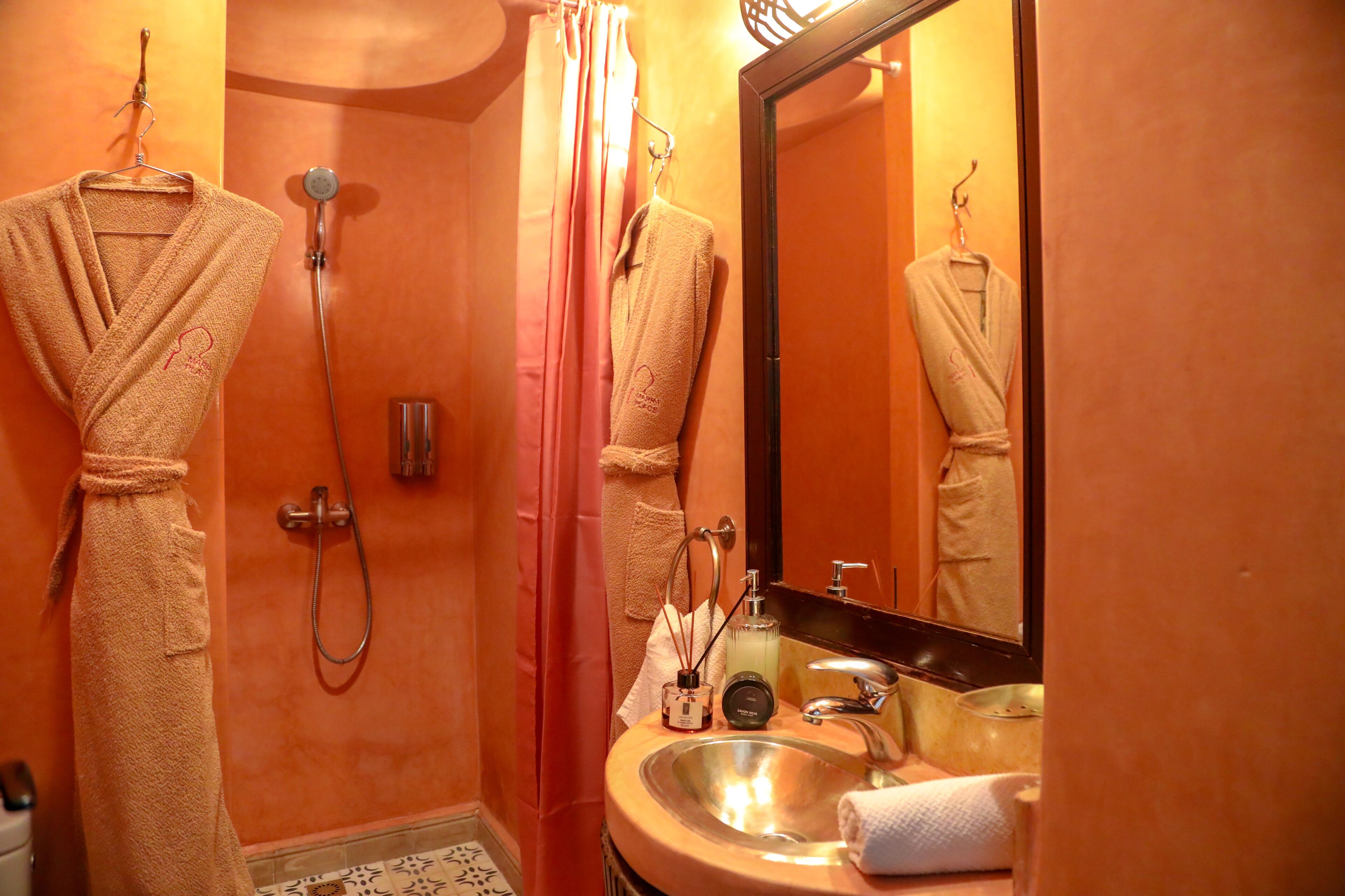 A bathroom with a sink, mirror, and two towels hanging on hooks.
