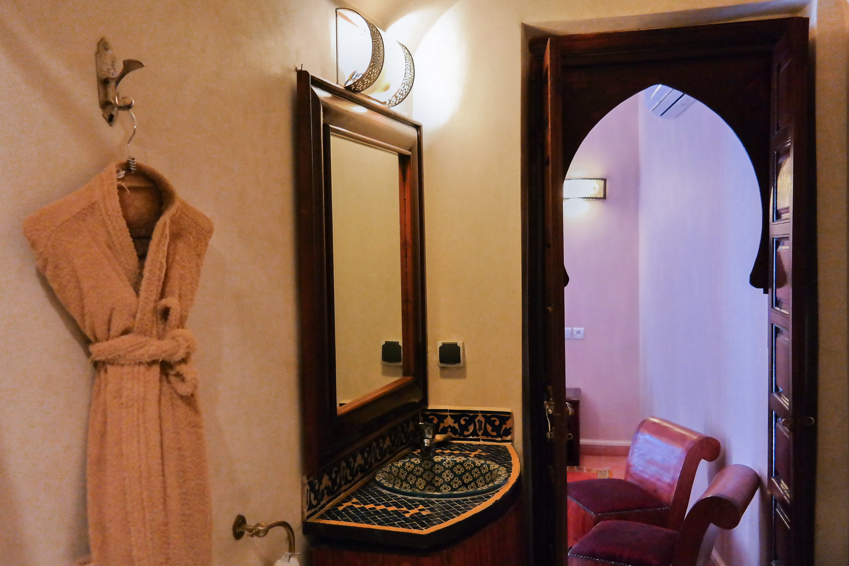Ein Badezimmer mit Handtuchhalter, Spiegel und einem Musterwaschbecken.