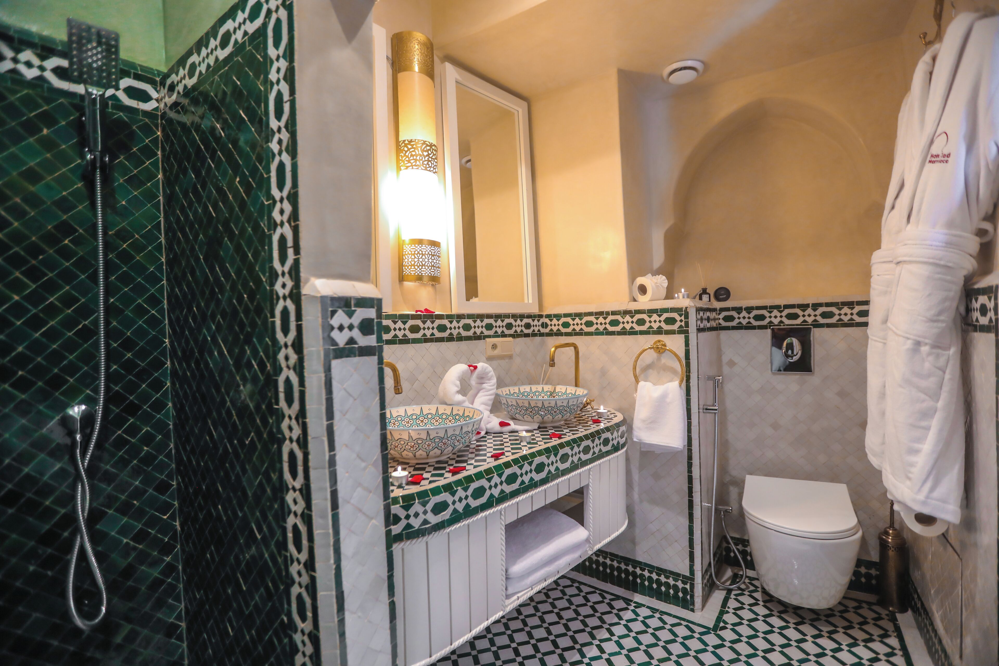 Ein Badezimmer mit Dusche, zwei Waschbecken, Toilette und Spiegel.