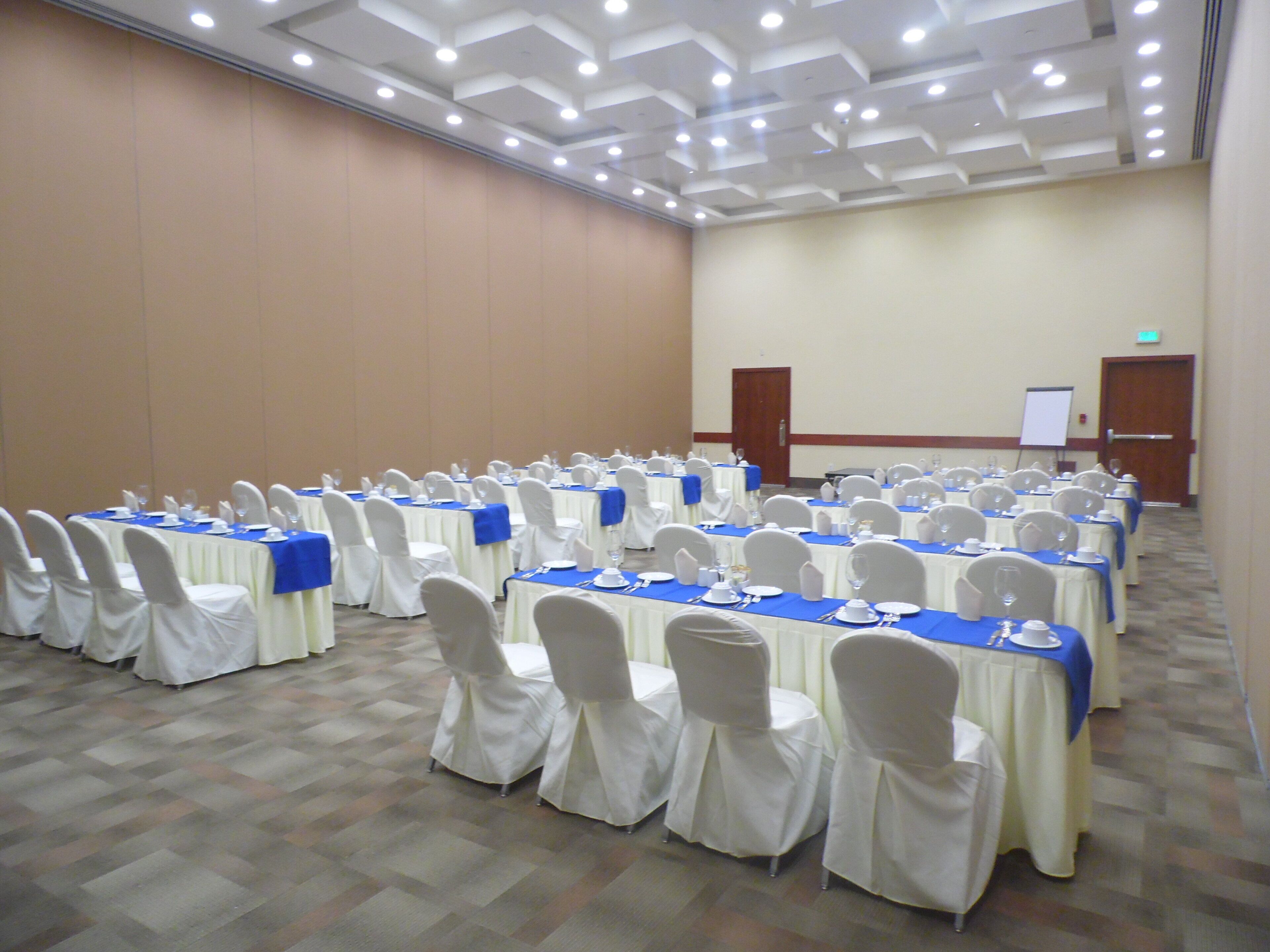 A conference room with rows of tables, chairs, and a whiteboard.