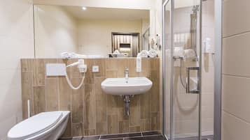 Ein modernes Badezimmer mit Toilette, Waschbecken und einer Duschkabine.