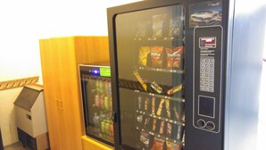 Una máquina expendedora con diferentes bocadillos y bebidas, incluyendo Doritos y otras marcas.