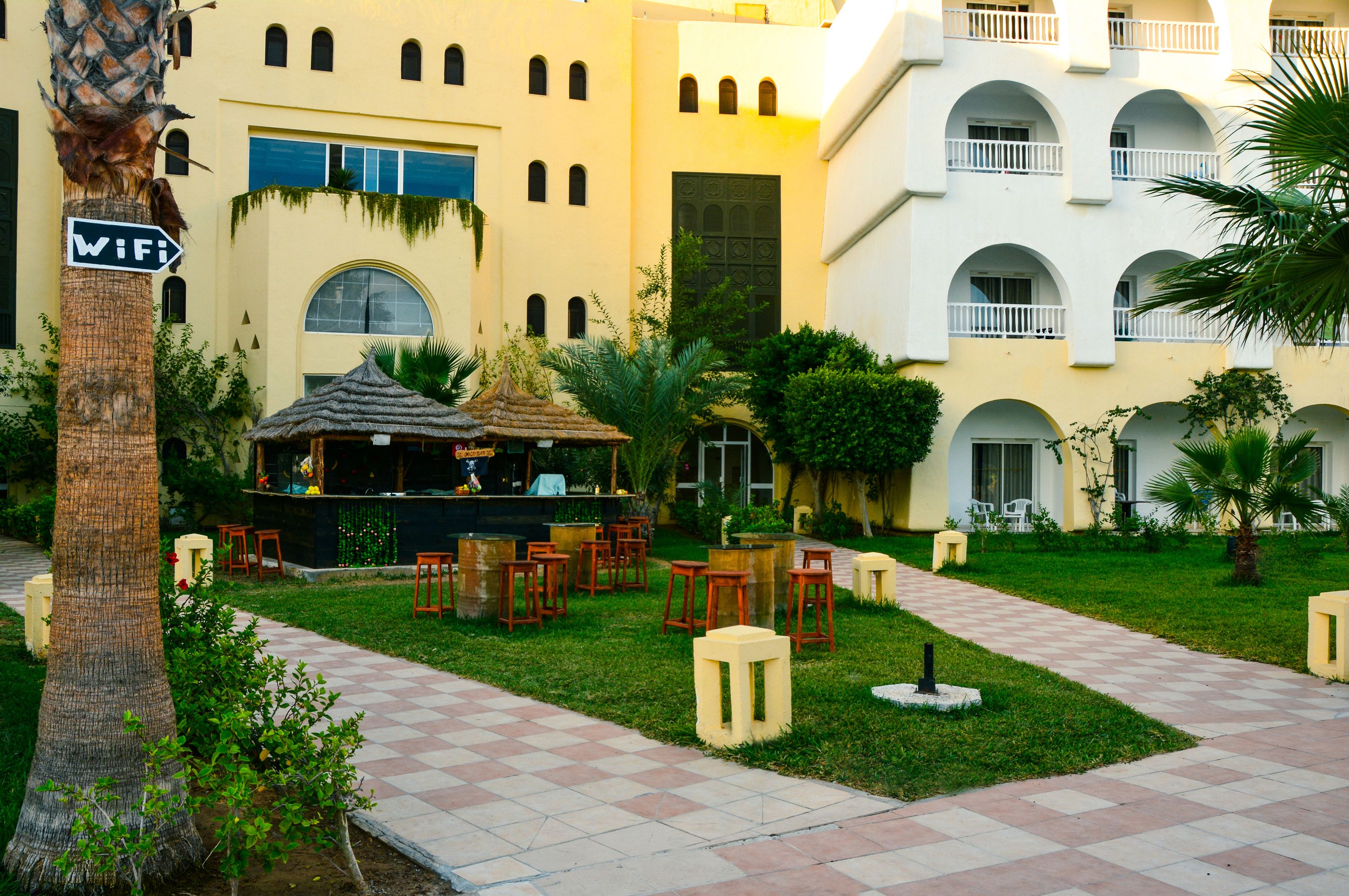 A courtyard with outdoor seating, a bar, and a sign indicating WiFi availability.