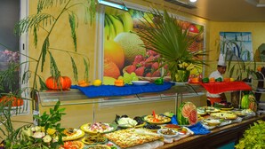 Un buffet proposant une variété de plats et de fruits frais.