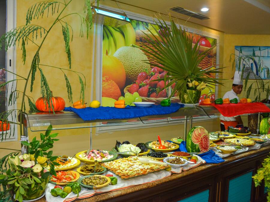 Un bufé con una variedad de platos y frutas frescas.