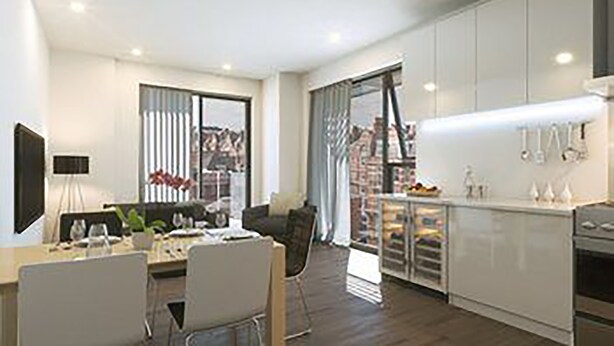 A modern kitchen with white cabinets, a dining area with a table and chairs, and a large window with curtains. - The Kensington Residencies (London)