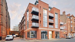 A multi-story building with a brick facade, large windows, and balconies. - The Kensington Residencies (London)