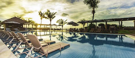 Una piscina al aire libre, sillones reclinables de piscina