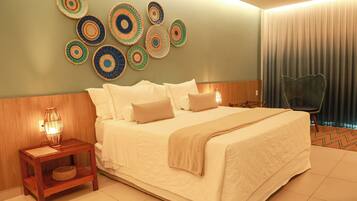 A hotel room with a bed, a nightstand, a chair, and a wall with decorative plates.