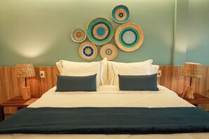 Ein Bett mit weißer und dunkelgrüner Bettdecke, zwei Kissen und einem Kopfteil mit einer runden Wanddekoration.