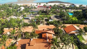 A resort with multiple buildings, a swimming pool, and a beach area.