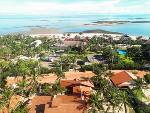 A resort with multiple buildings, a swimming pool, and a beach area.
