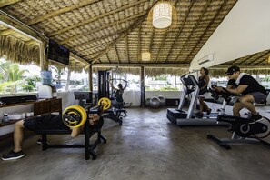 A gym with exercise equipment, a bench, and a treadmill. - Pousada Manati (Cajueiro da Praia)