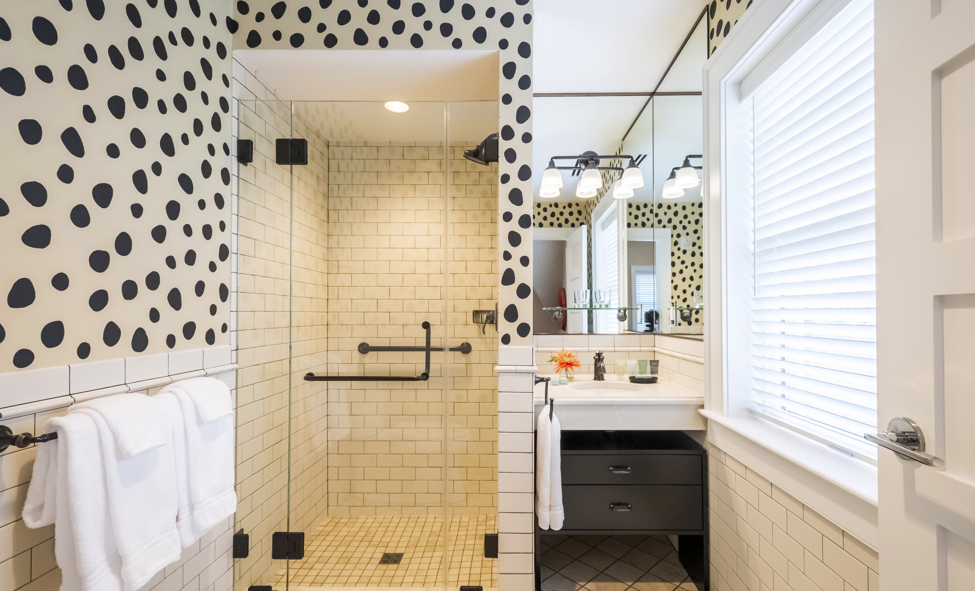 A modern bathroom with a shower, a sink, and a mirror.