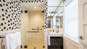 A modern bathroom with a shower, a sink, and a mirror.