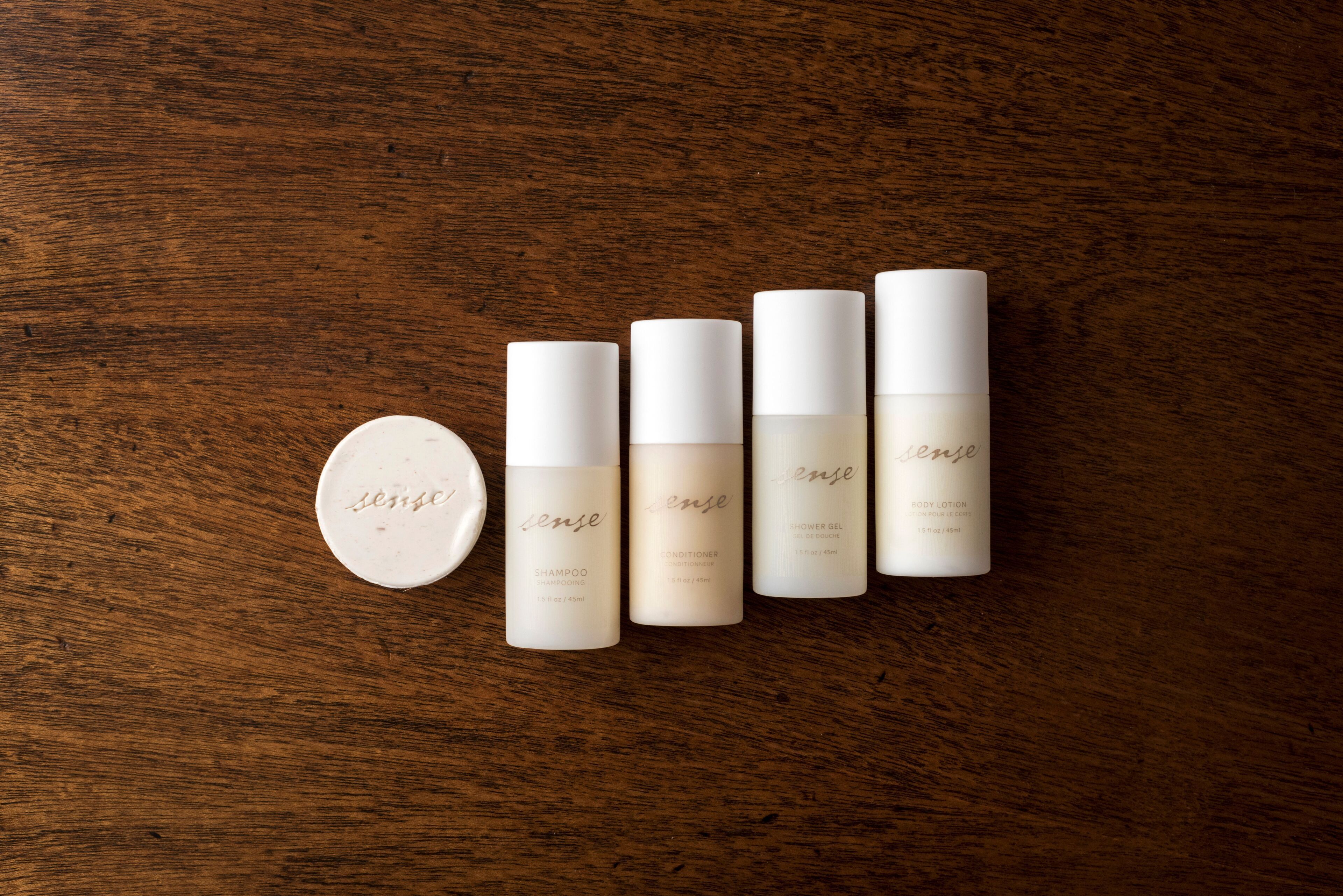 A set of five skincare products on a wooden surface.