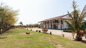 A building with a flat roof and a covered porch area. - Coconut Grove House B and B (Hengchun)