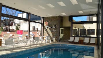 An indoor swimming pool with clear glass walls, a tiled floor, and a sign reading "Florida Spa".