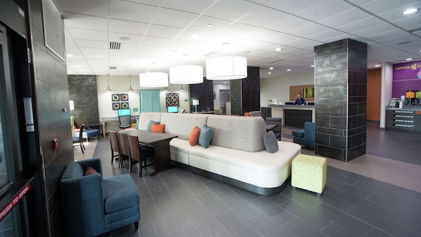 A modern lobby with a seating area, a reception desk, and a coffee station. - Home2 Suites by Hilton Tulsa Hills (Tulsa)