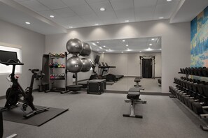 A gym with exercise equipment, weights, and a mirror. - Home2 Suites by Hilton Anchorage / Midtown (Anchorage)