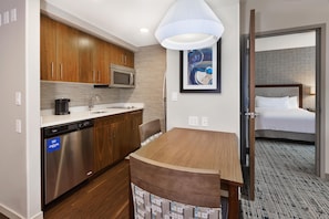 Une chambre d’hôtel équipée d’une kitchenette, d’un lit et d’une salle de bain.