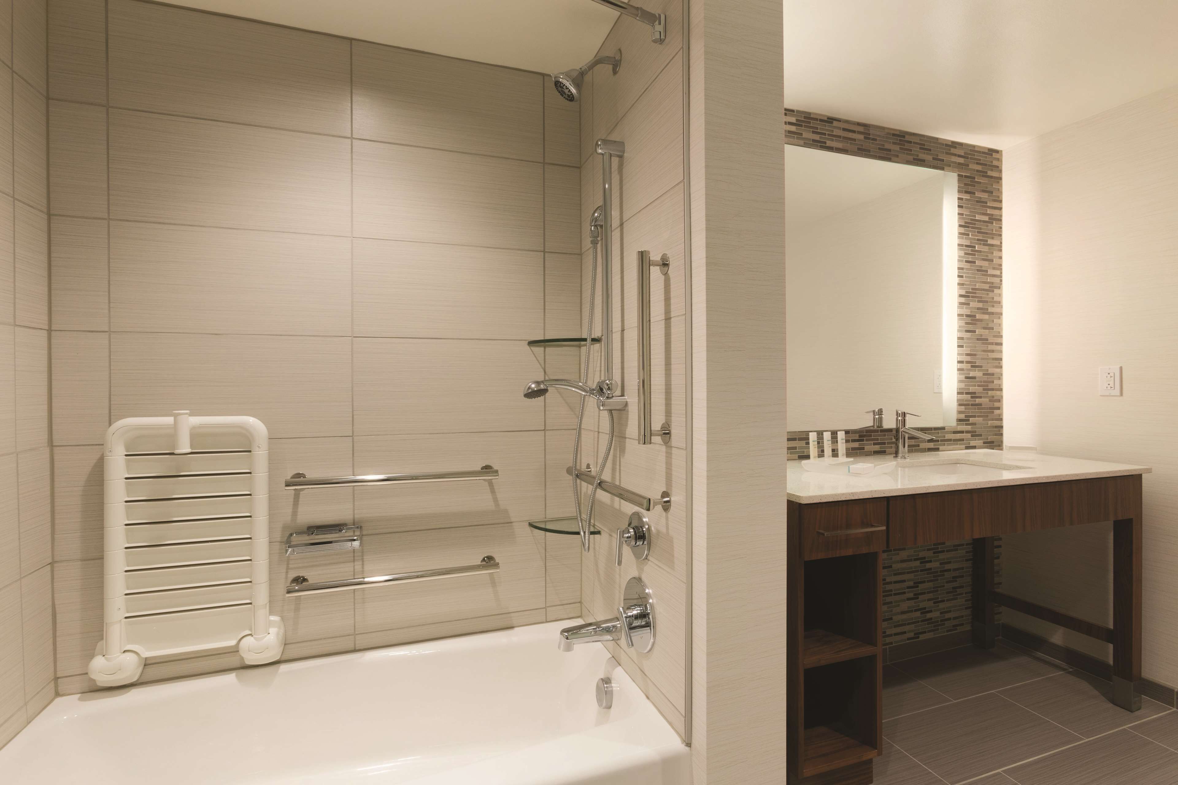 A modern bathroom with a bathtub, shower, and vanity.