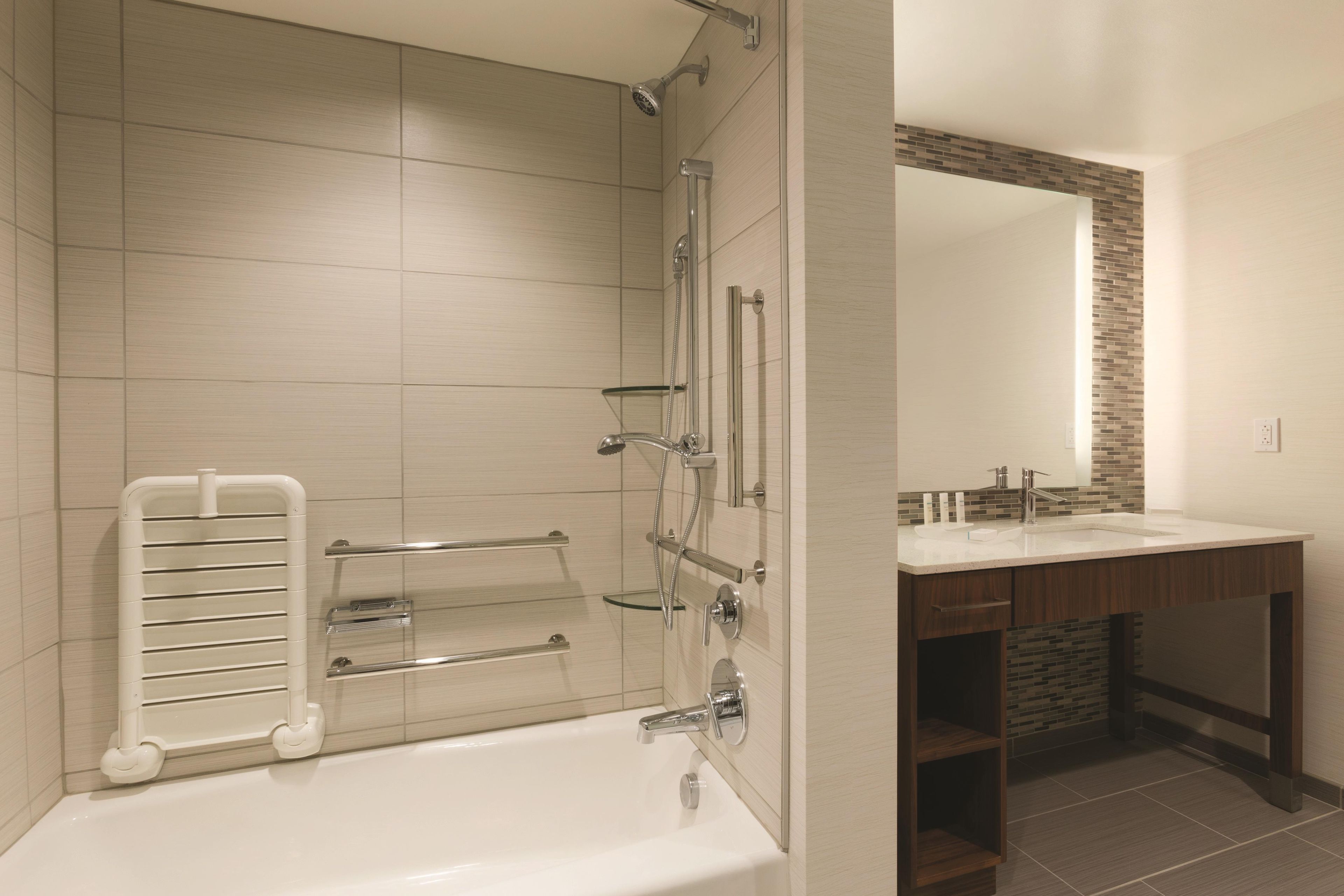 A modern bathroom with a walk-in shower, a glass-enclosed bathtub, and a vanity with a mirror.
