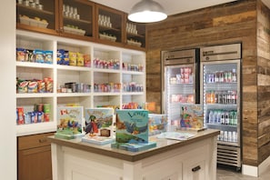 Una sección infantil con pasillos de aperitivos, un refrigerador y un mostrador con libros.