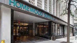 L’entrée d’un hôtel, avec une enseigne indiquant « HOMEWOOD SUITES BY HILTON ».