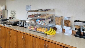 A breakfast station with various food items and a coffee machine. - Perfect Inns & Suites (Weyburn)