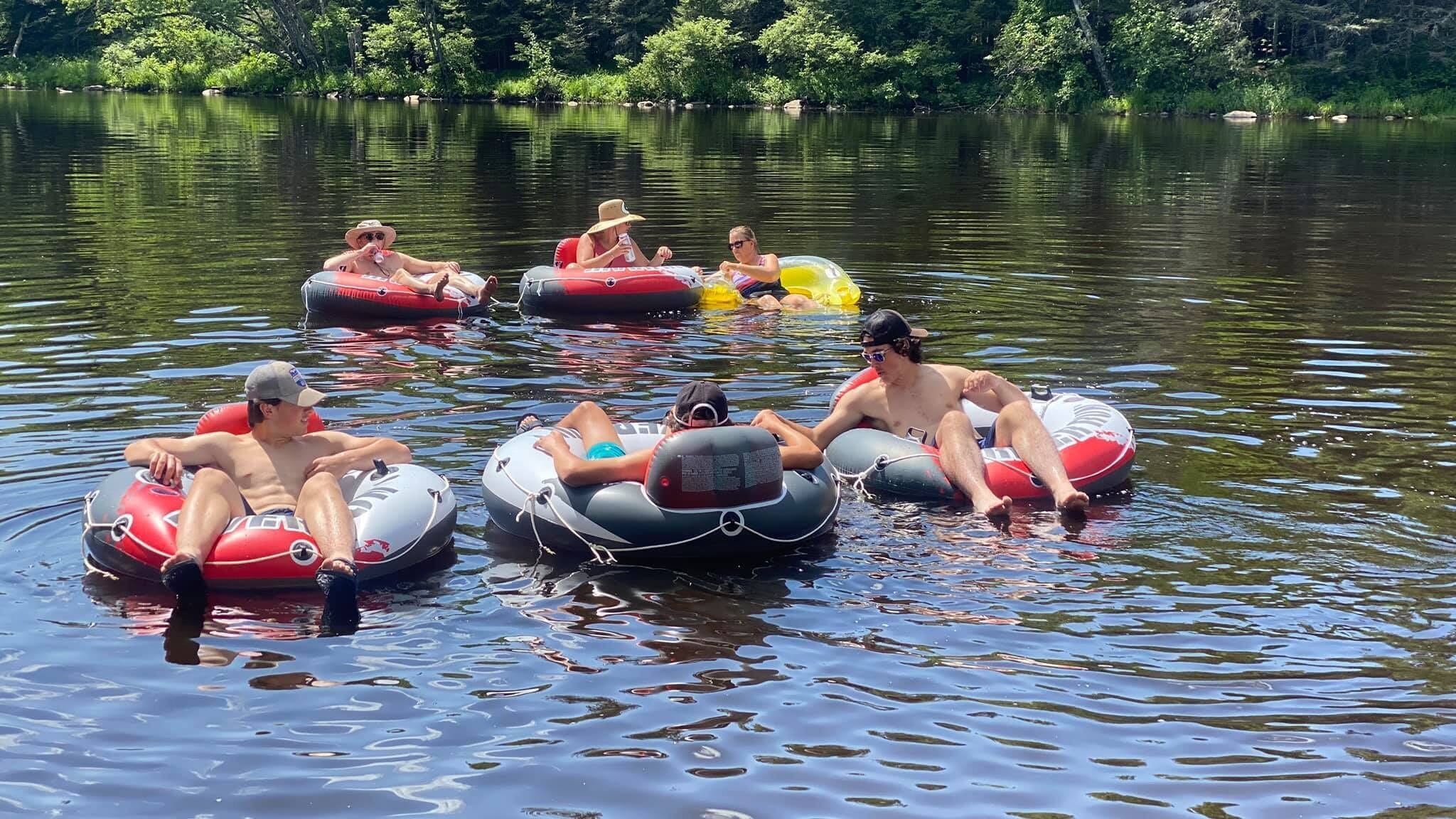 People floating on water in inflatable tubes.