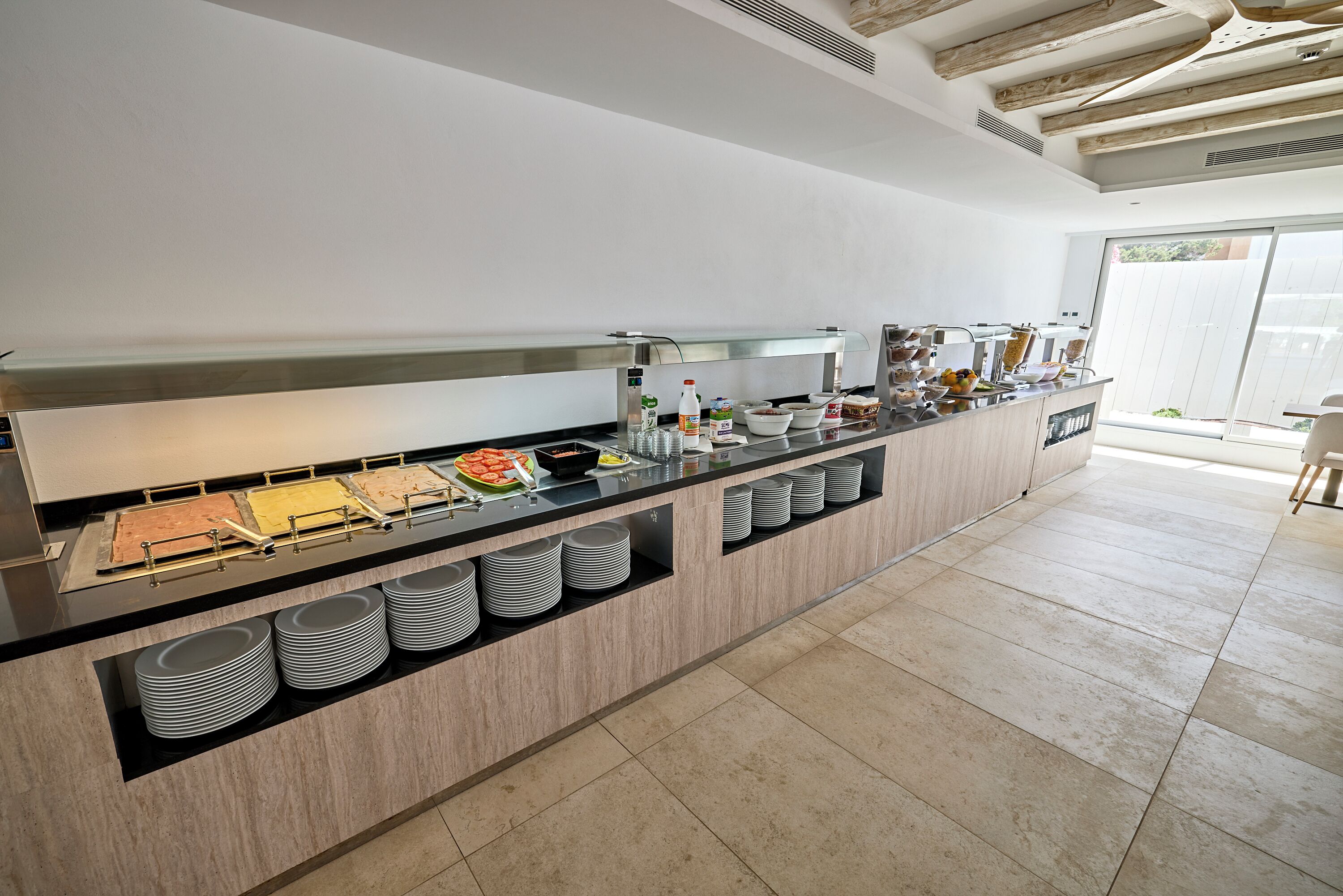 A buffet setup with various food items and utensils.