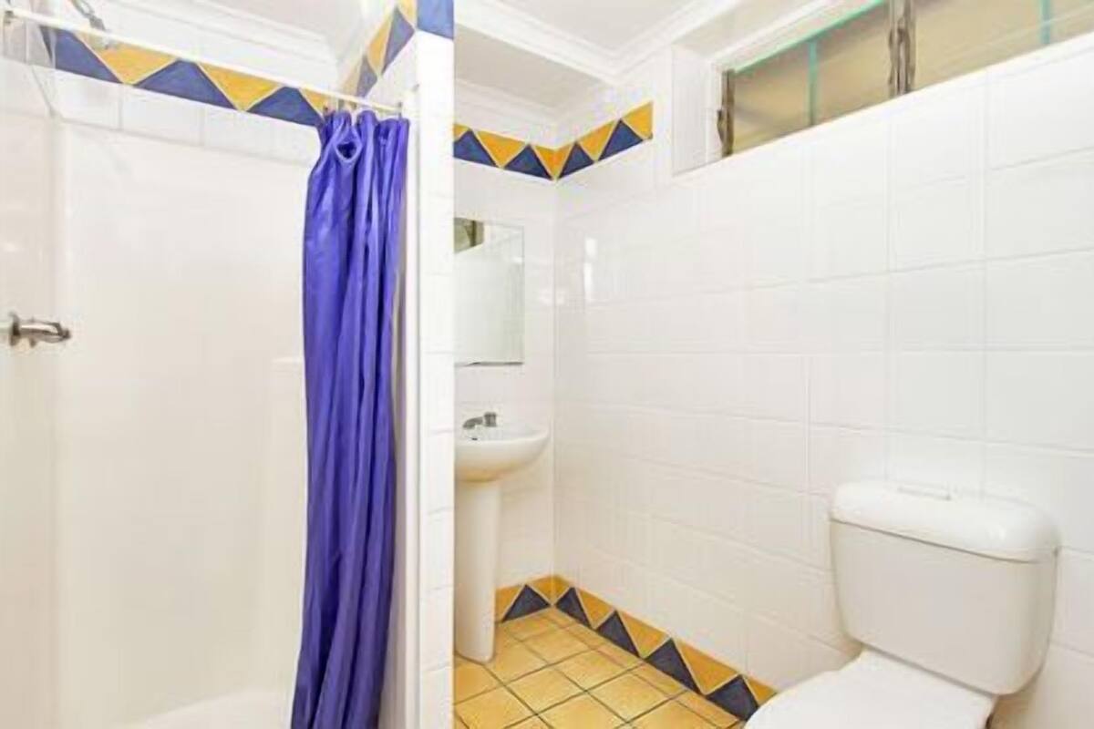 A bathroom with a shower, sink, and toilet.