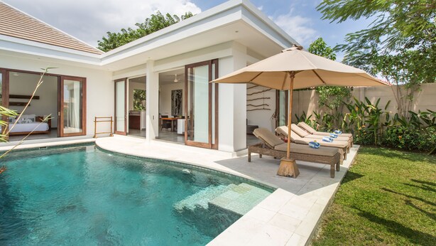 A modern house with a swimming pool, outdoor seating, and a garden.
