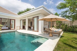 A modern house with a swimming pool, outdoor seating, and a garden. - Gajah Villas Bali by Nagisa Bali (Seminyak)