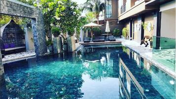 Een buitenzwembad, parasols voor strand/zwembad