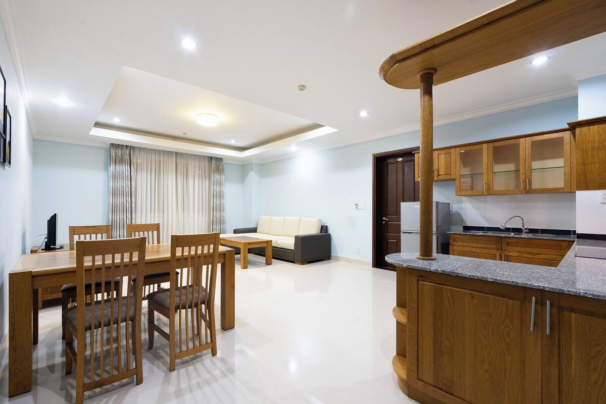 A modern kitchen with wooden cabinets and a granite countertop.
