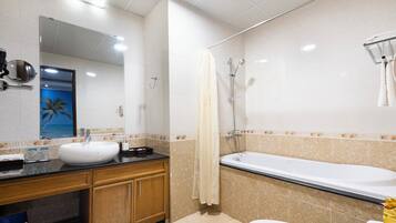 A bathroom with a sink, mirror, shower, and toilet.