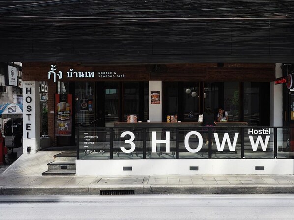 A Hostel with a modern facade, a glass barrier, and a sign indicating '3 SHOWw'.