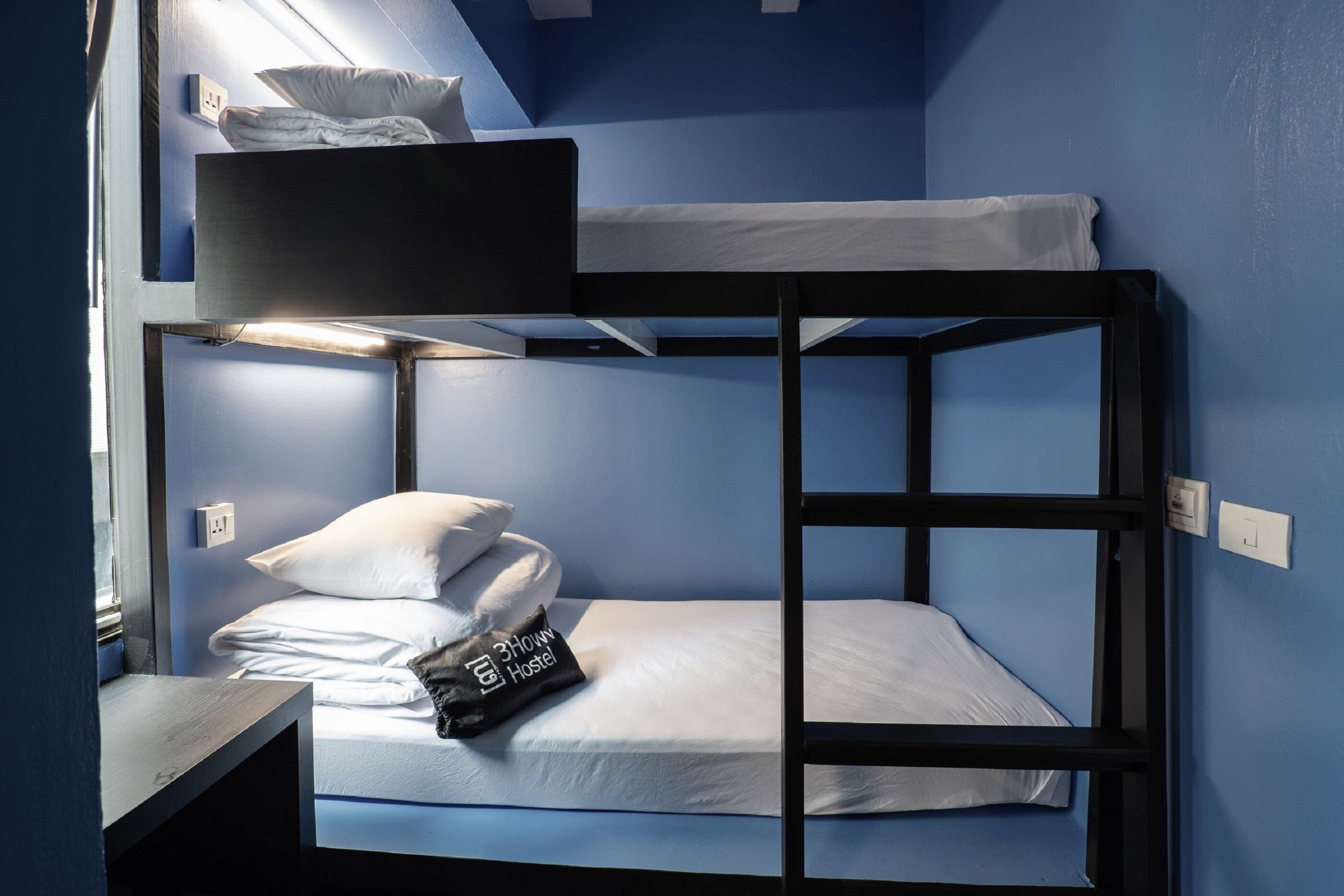 A bunk bed with a headboard, pillows, and a blanket.