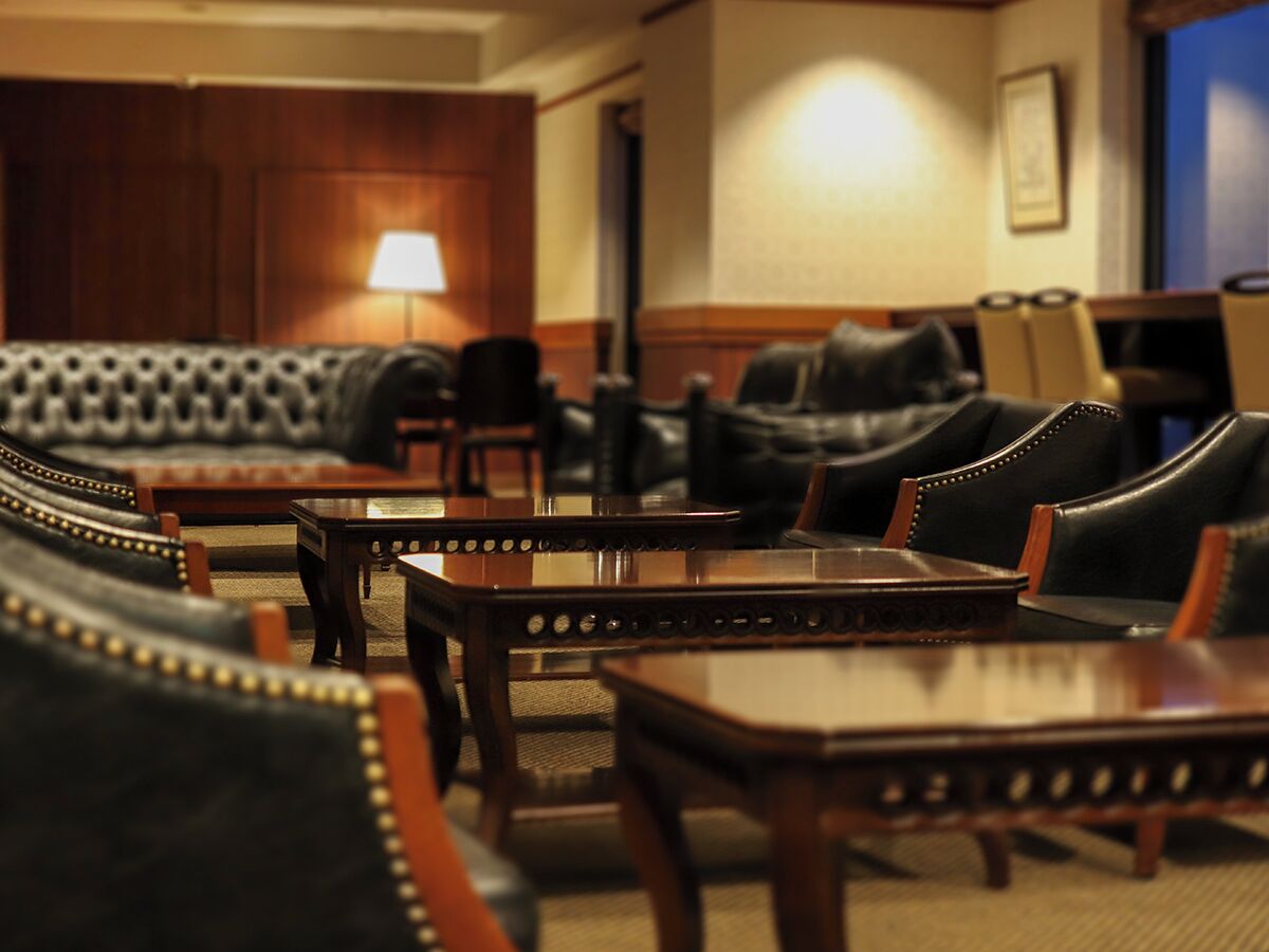 A hotel lobby with leather sofas and wooden tables.